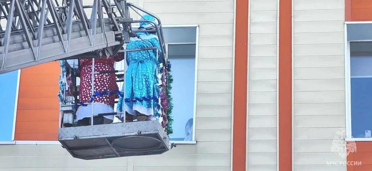 Дед Мороз и Снегурочка поднялись к окнам маленьких пациентов онкодиспансера на пожарной автолестнице Дед Мороз и Снегурочка поднялись к окнам маленьких пациентов онкодиспансера на пожарной автолестнице